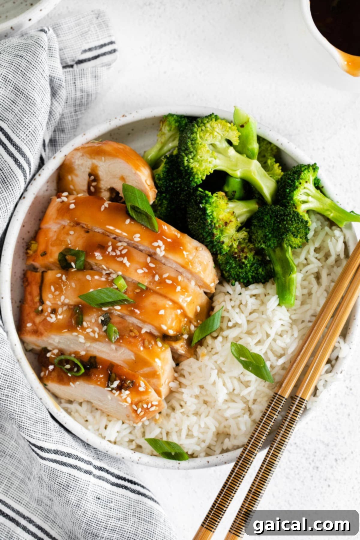 Seriously delicious baked teriyaki chicken breast comes together with easy-to-find ingredients. This teriyaki chicken comes out so tender and saucy! Sliced teriyaki chicken next to vibrant broccoli and fluffy white rice, ready to serve.