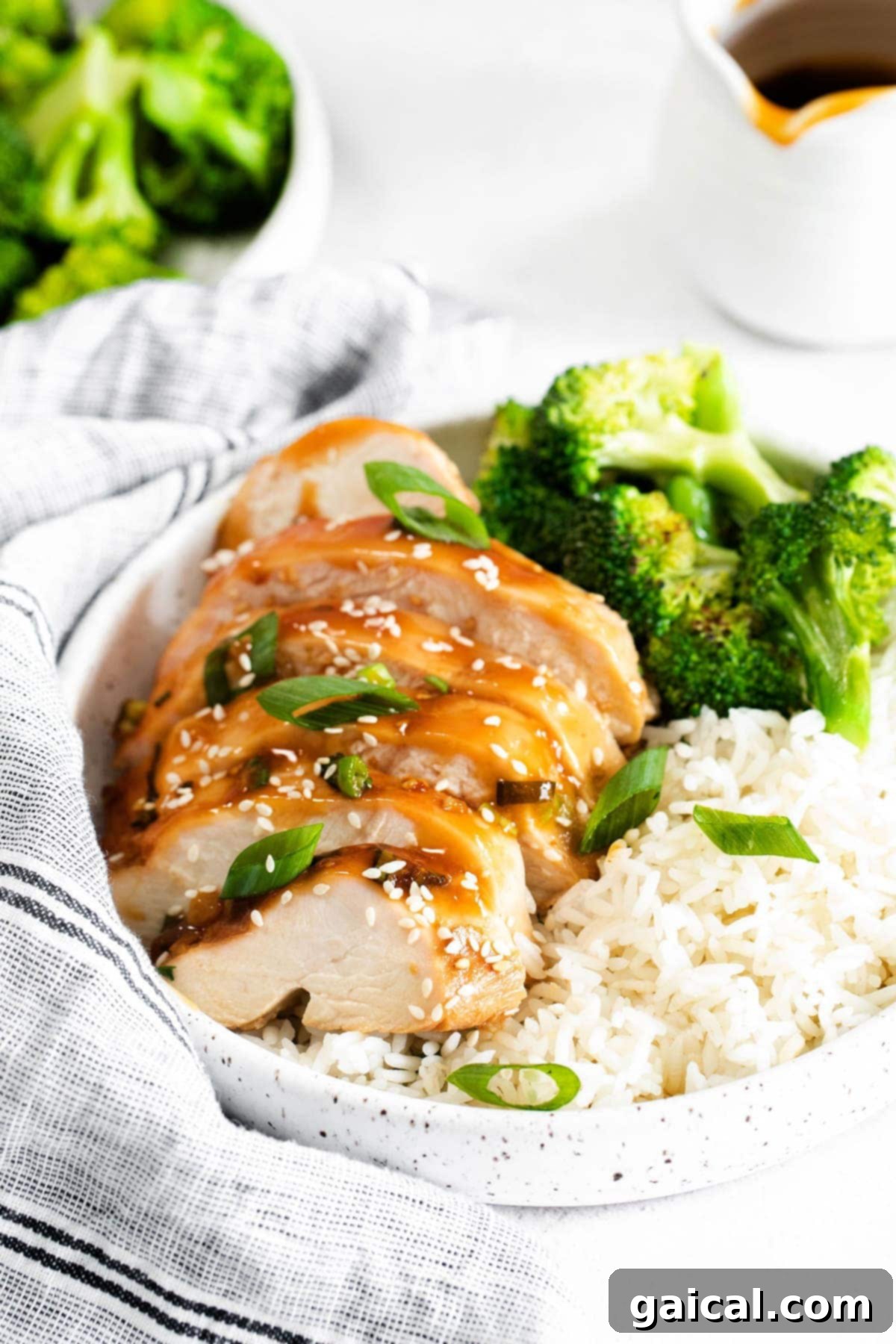 When in doubt, make this easy Baked Teriyaki Chicken Breast. The chicken is marinated in an easy homemade teriyaki chicken marinade and then baked in a casserole dish until tender. Sliced teriyaki chicken breast served with white rice and steamed broccoli in a bowl, ready to eat.
