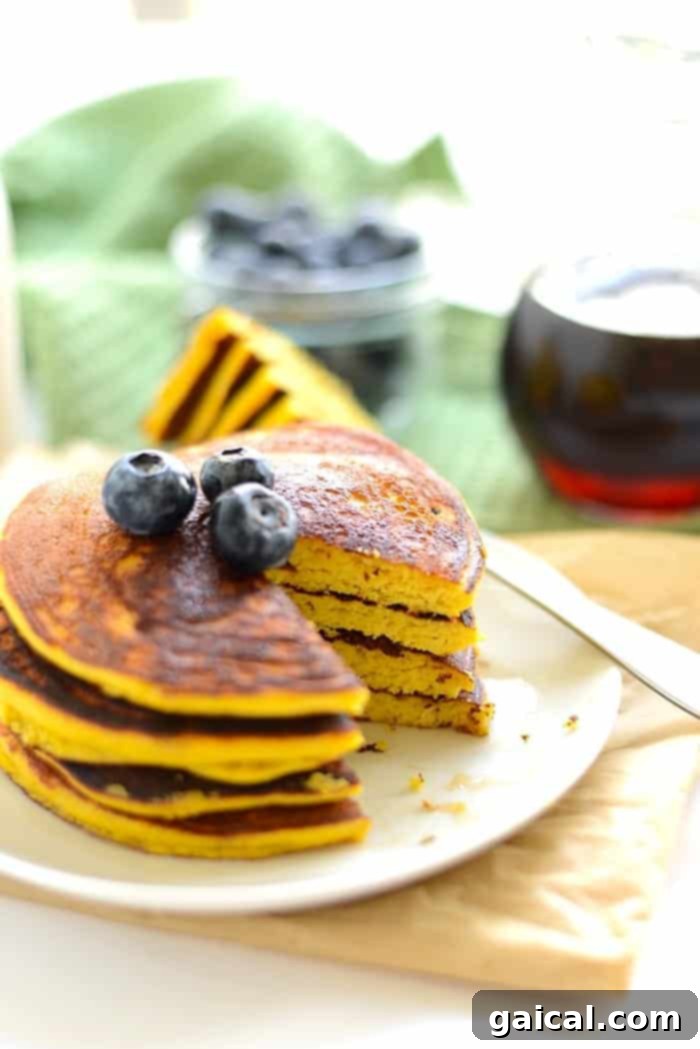 A close-up shot of a stack of golden coconut flour pancakes, showing their fluffy texture and delicious appearance, ready for breakfast.