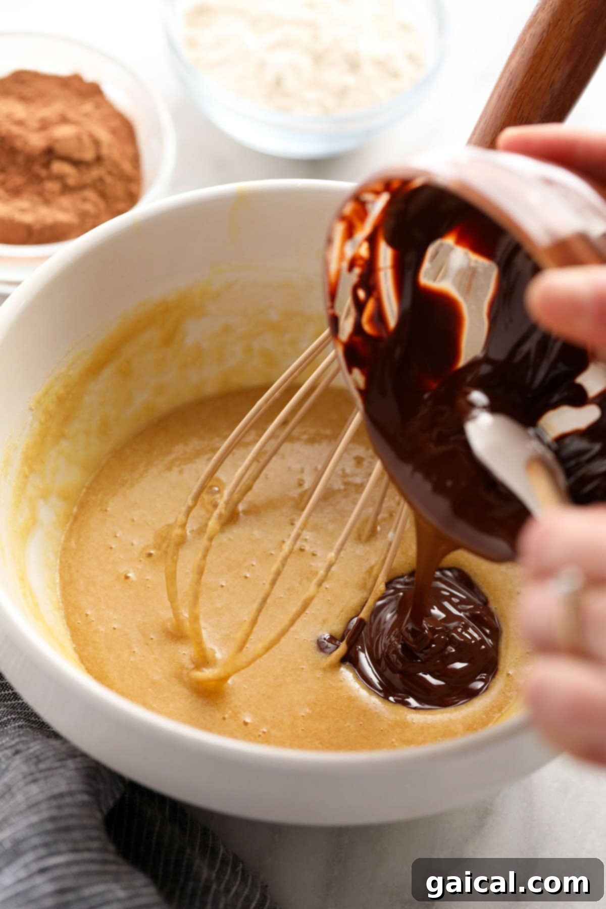 Pouring melted chocolate into brownie batter