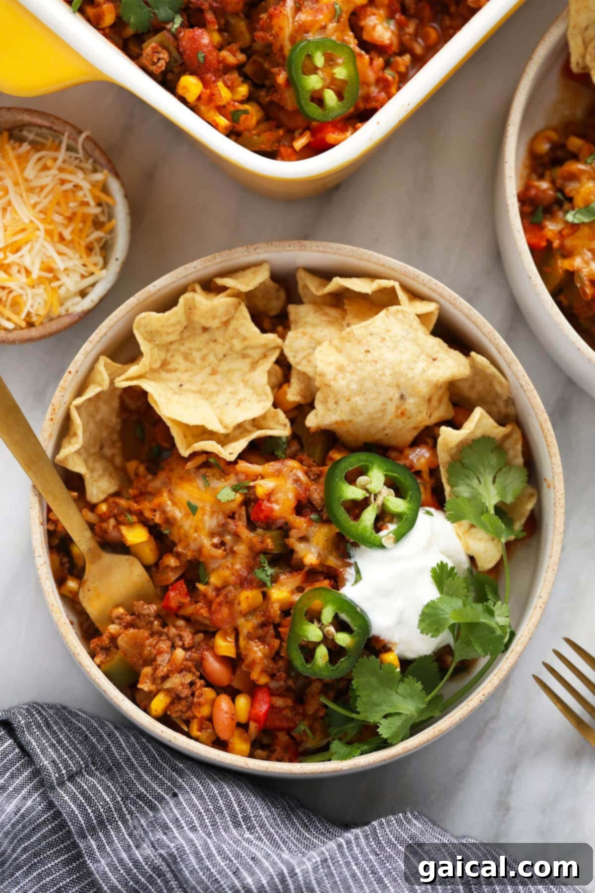 Mexican casserole in a bowl with tortilla chips, ready to be enjoyed.