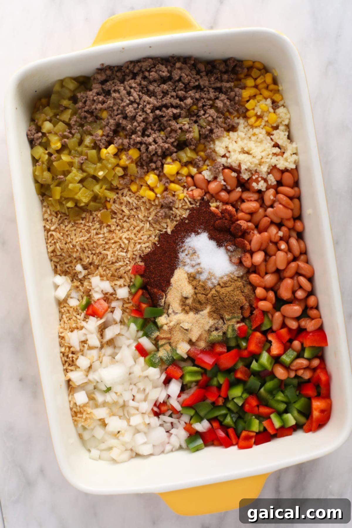 All the vibrant ingredients for an easy Mexican casserole arranged beautifully in a casserole dish before baking.