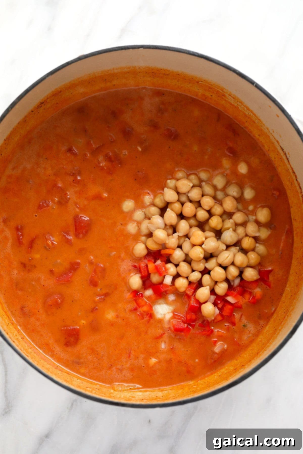 Simmering Chickpea Curry Sauce Close-up of the rich, creamy chickpea curry sauce simmering in a Dutch oven, bubbling gently.