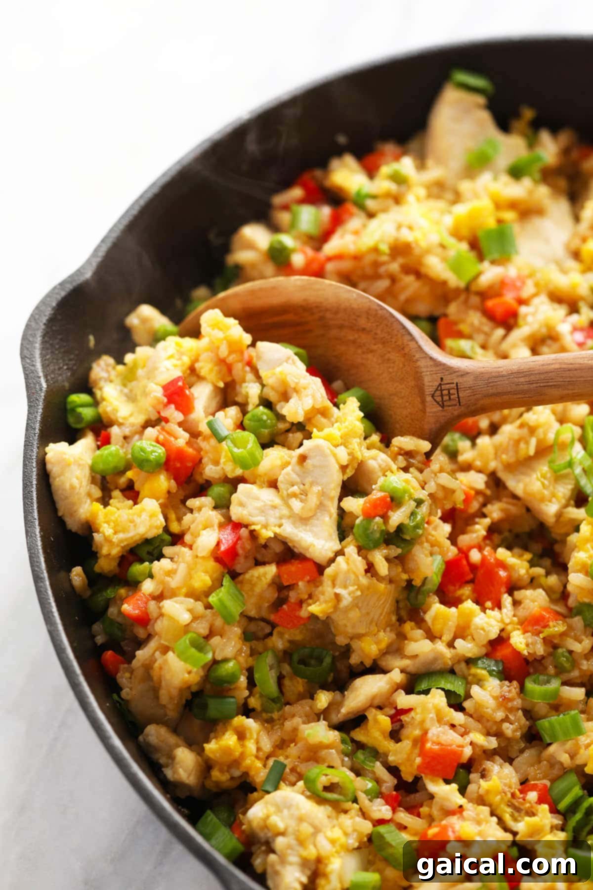 Delicious chicken fried rice simmering in a large frying pan, ready to be served.