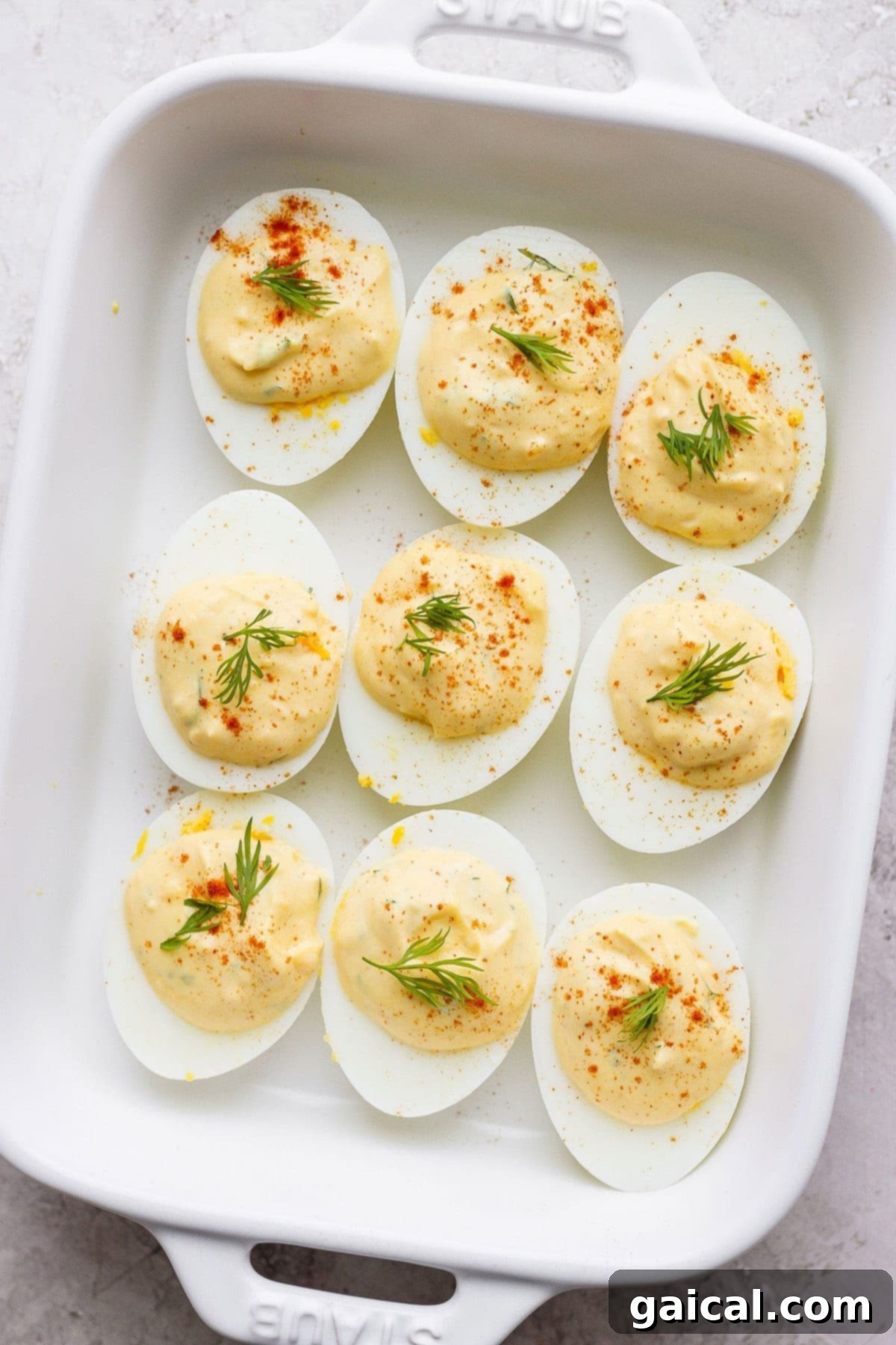 Perfectly crafted easy deviled eggs, a classic appetizer for any occasion. Easy deviled eggs in a serving dish, beautifully garnished with paprika and fresh dill sprigs, ready to be enjoyed.