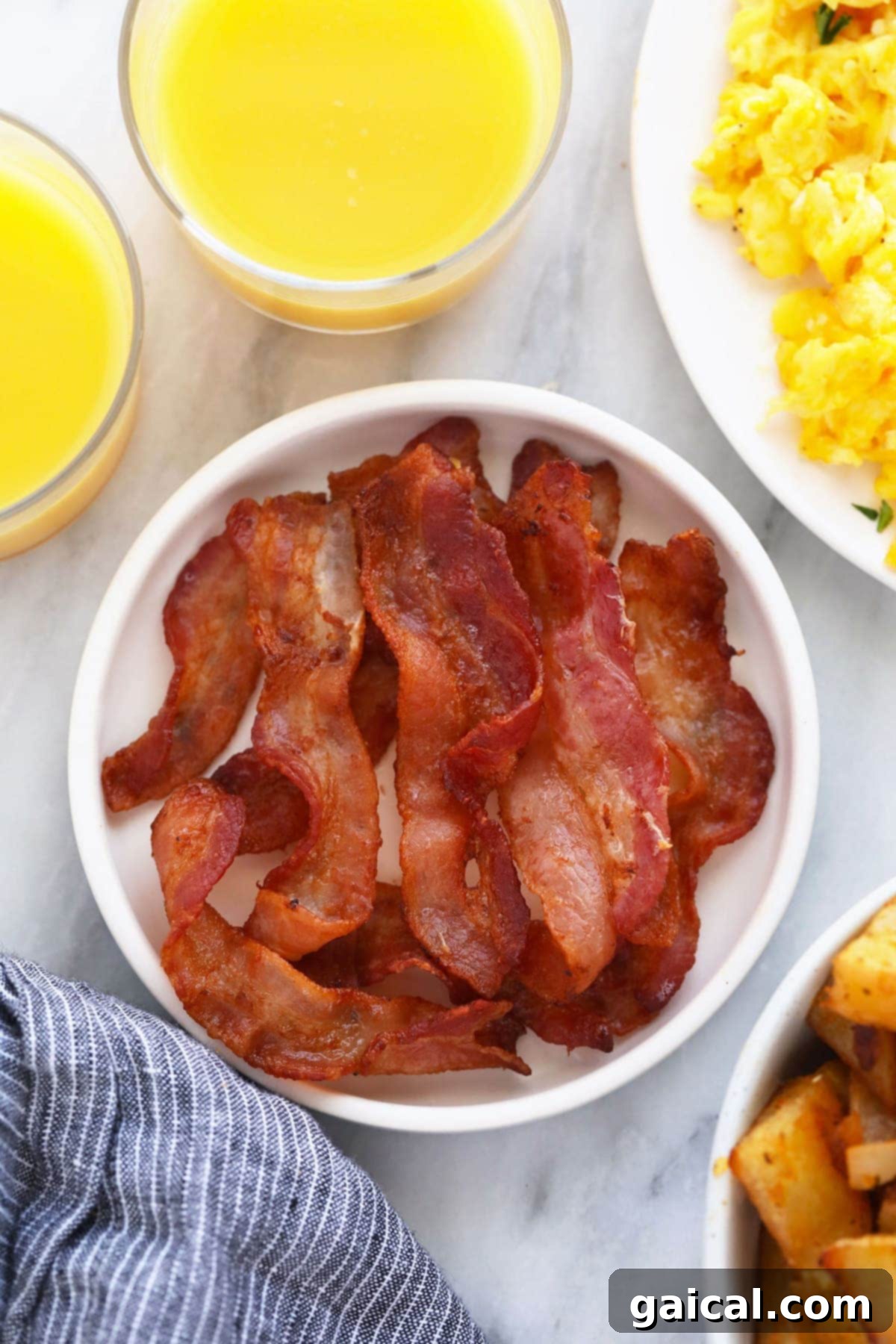 Perfectly cooked, golden-brown crispy bacon slices arranged on a plate.