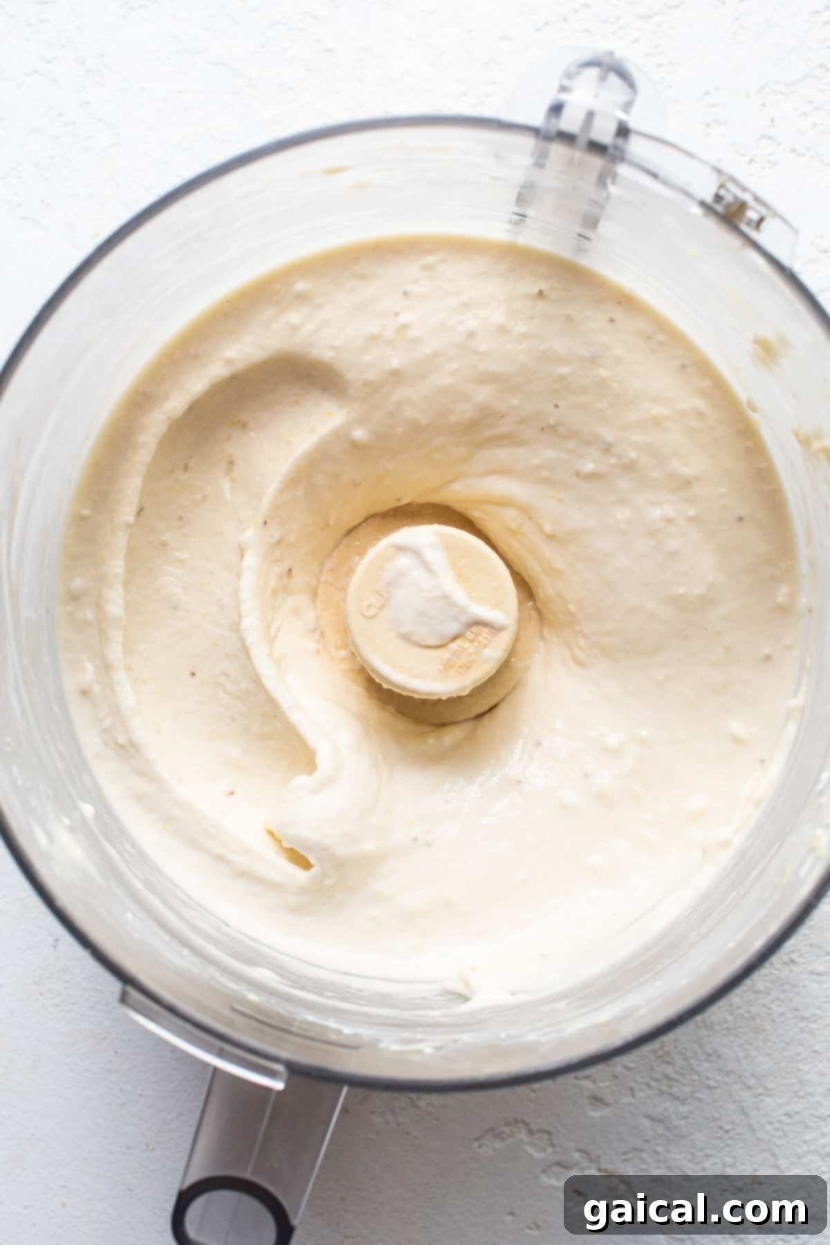 A blender with a white substance in it, being blended to make nice cream.