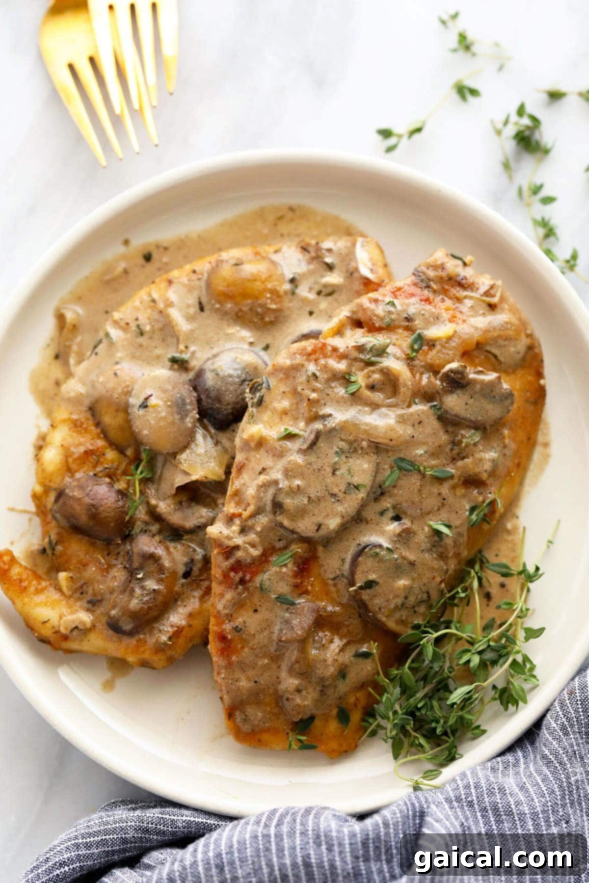 Creamy Chicken Marsala with Pan-Seared Chicken and Mushroom Sauce A beautifully plated dish of Chicken Marsala, showcasing golden-brown chicken cutlets generously topped with a luscious mushroom and Marsala wine sauce, garnished with fresh herbs.