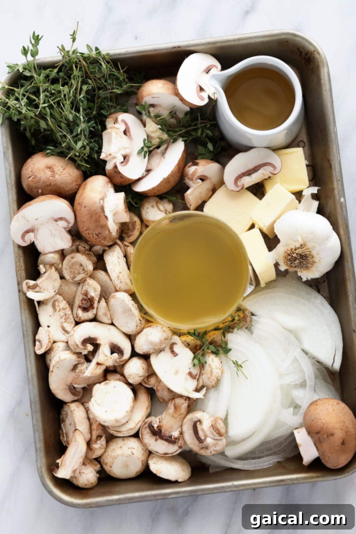 Chicken Marsala Recipe: Essential Ingredients Display Assorted fresh ingredients for Chicken Marsala laid out on a wooden cutting board, including neatly sliced crimini mushrooms, minced garlic and onion, and bundles of fresh thyme.