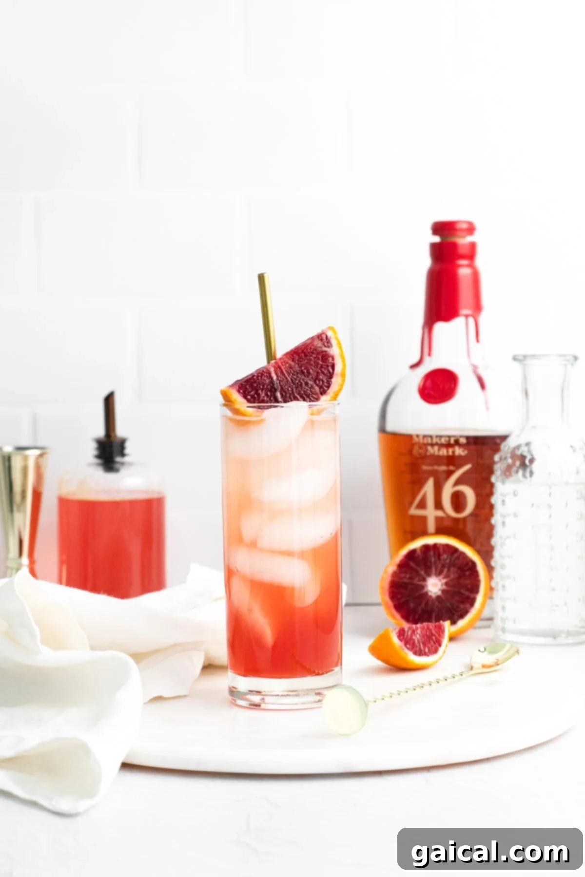 A collection of various blood orange cocktails and drinks arranged beautifully on a table, ready for a gathering.