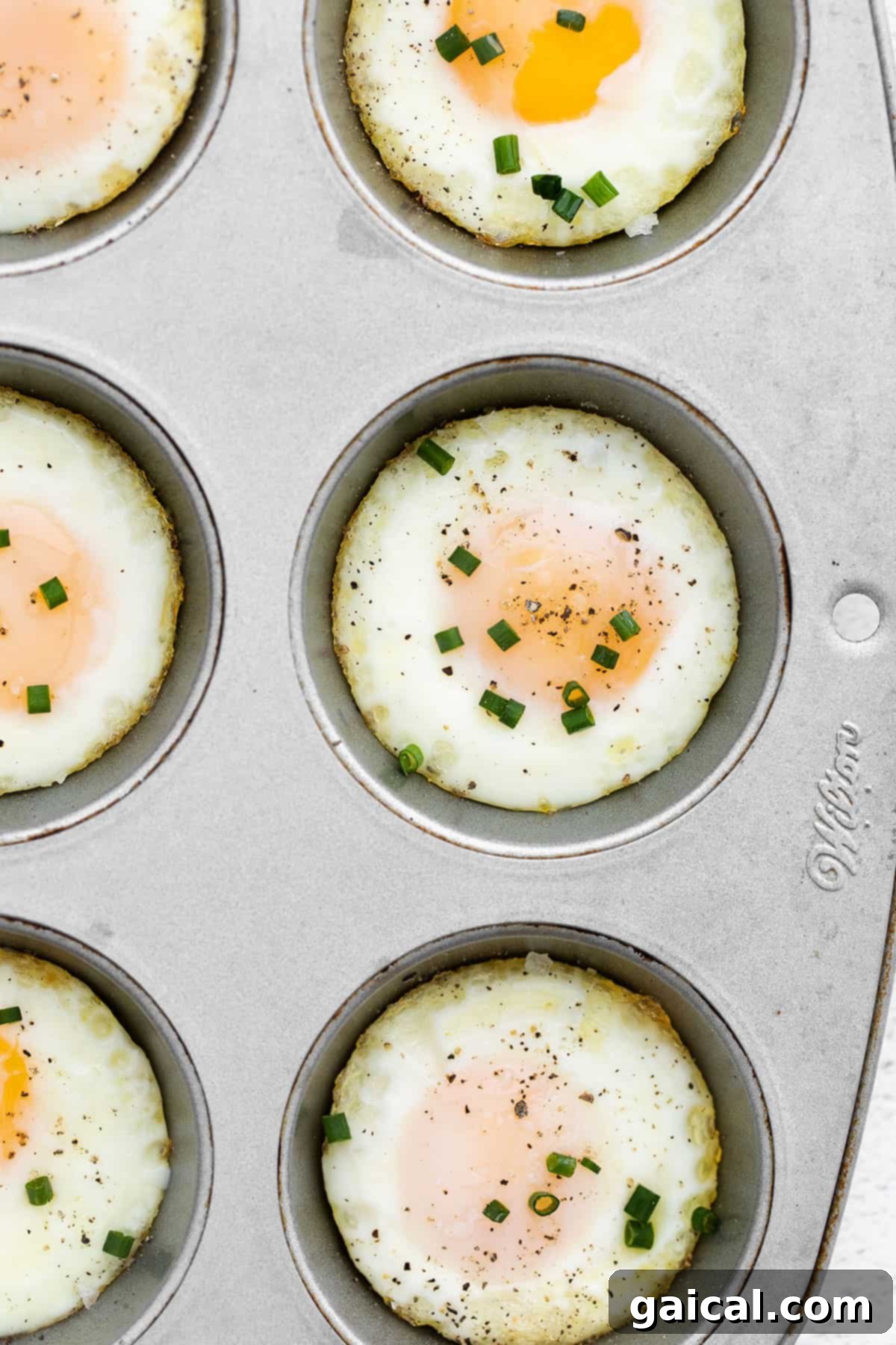 Baked Egg Delights 2 Baked eggs in oven using muffin tin and chives, ready to serve.