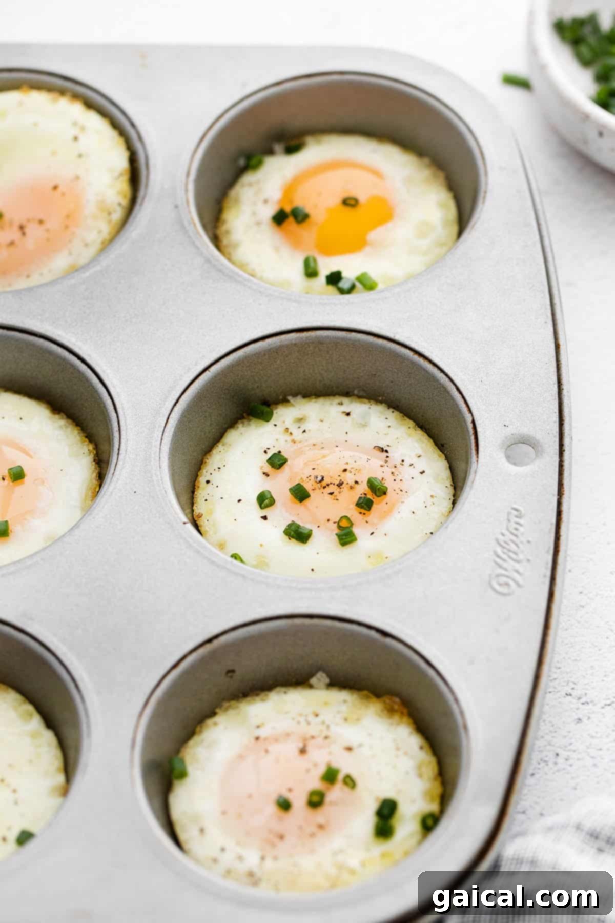 Baked Egg Delights 4 Instructions for baking eggs in the oven using a muffin tin, topped with fresh chives, step-by-step.
