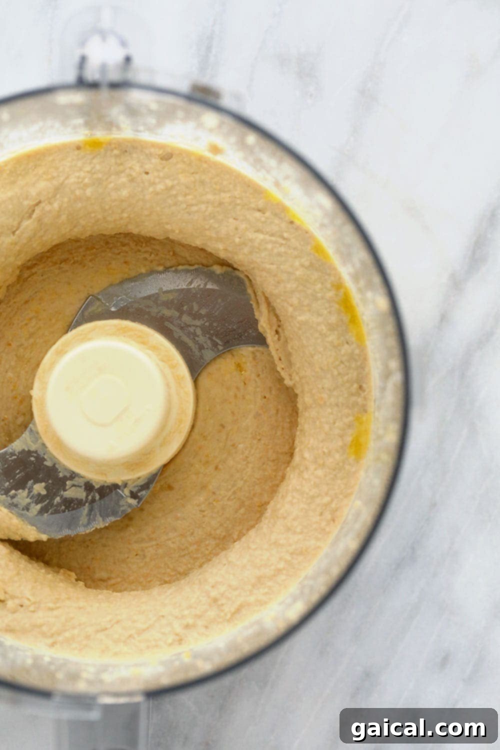 Creamy Homemade Hummus Made Easy 4 Lemon garlic hummus being blended to perfection in a food processor, showing its creamy texture.