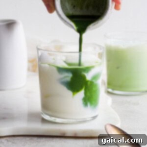 Iced matcha latte in a glass with ice.