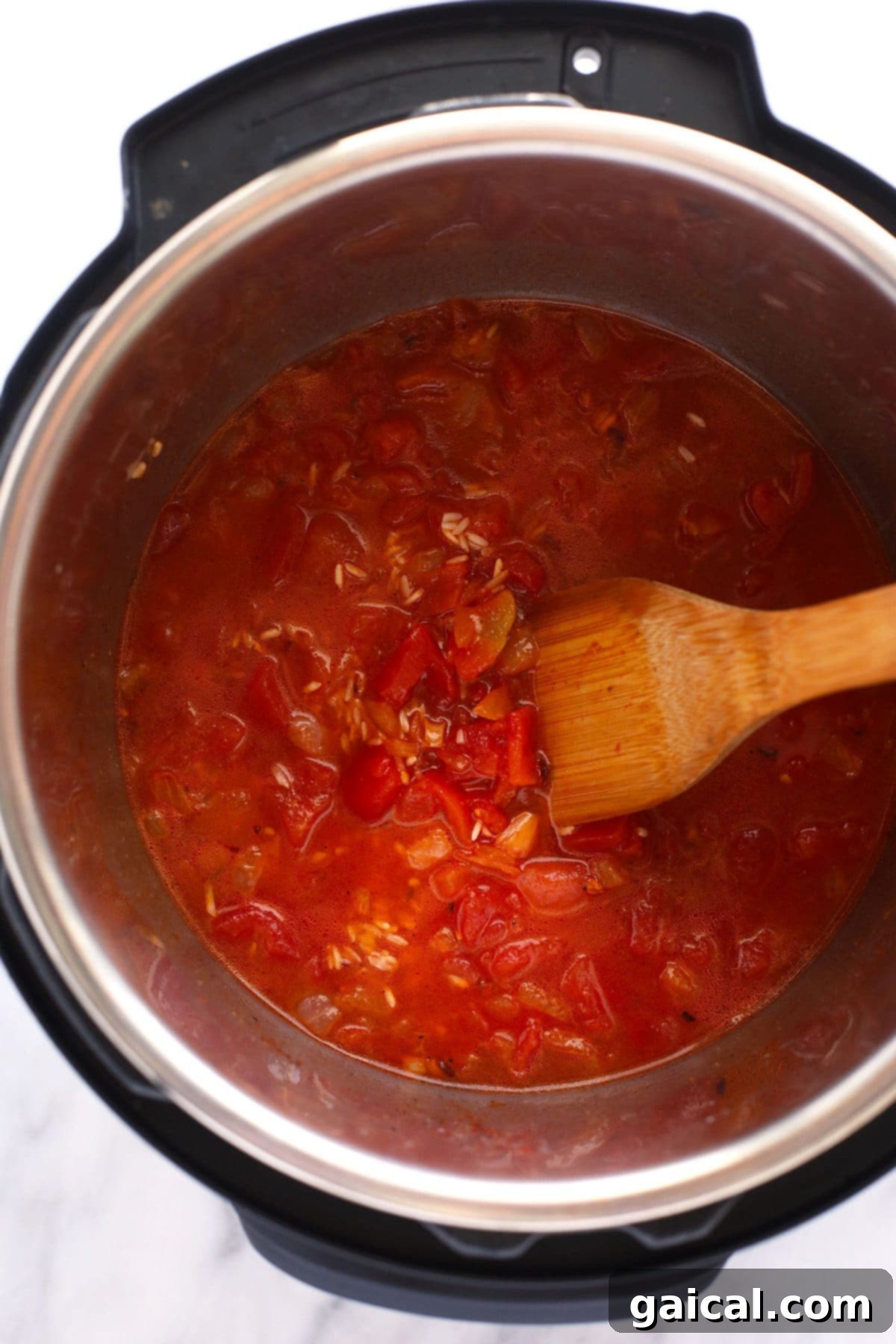 Easy Instant Pot Jambalaya 6 A close-up view of the Instant Pot containing the liquid, uncooked rice, diced vegetables, and broth for Jambalaya, perfectly layered and ready for cooking under pressure.