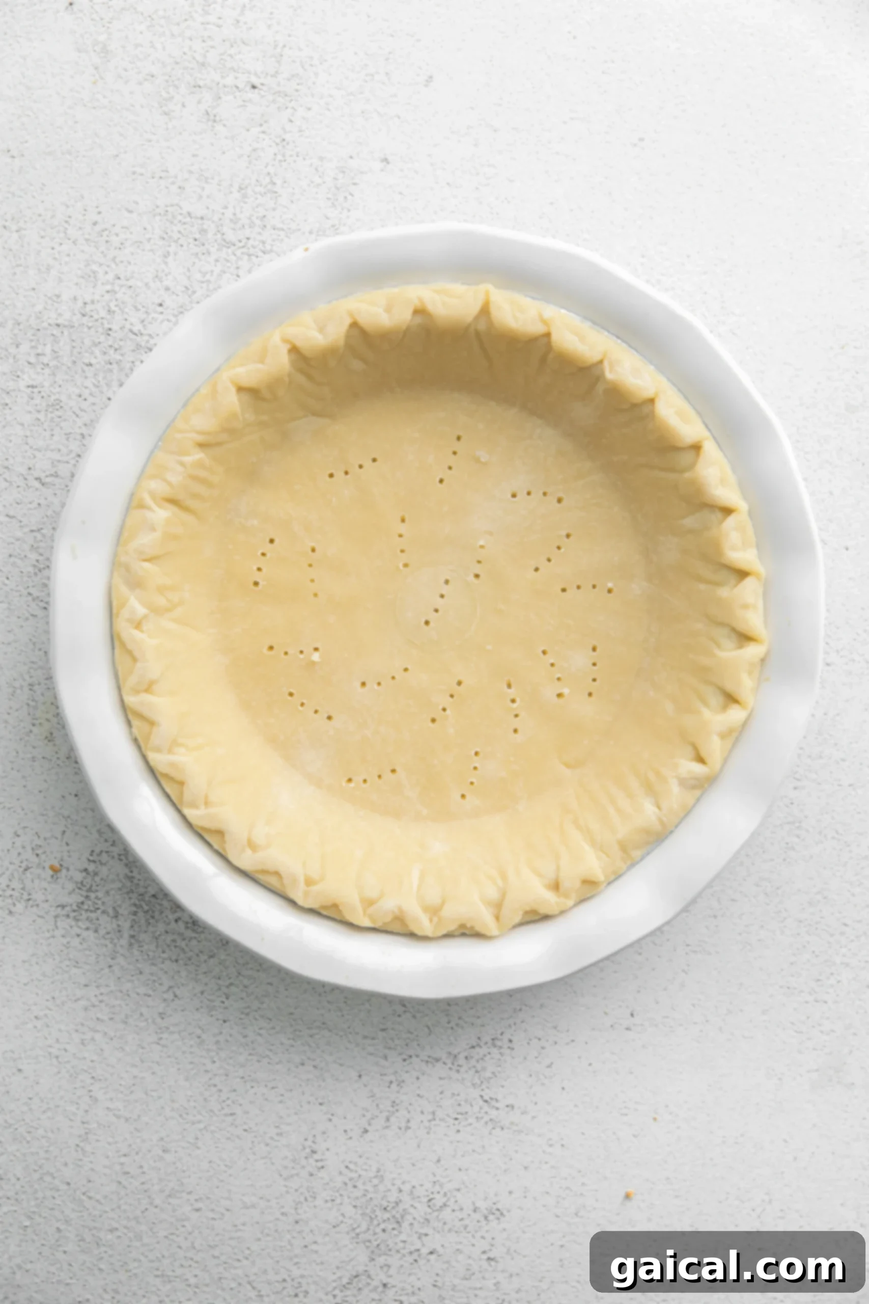 Simple & Savory Spinach Quiche 4 A pie crust ready for filling, with small fork pricks at the bottom to prevent bubbling. This image highlights the preparatory step of ensuring an even bake for the quiche crust.