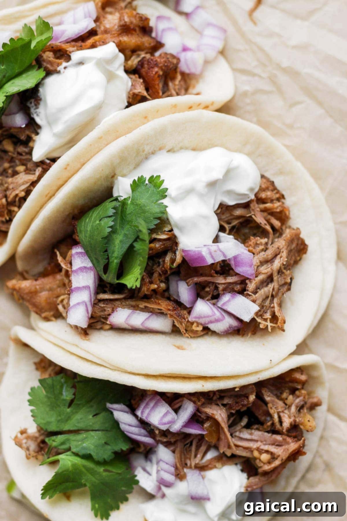 Perfect Homemade Carnitas 11 Crispy slow cooker carnitas served in a fresh taco shell with vibrant toppings.