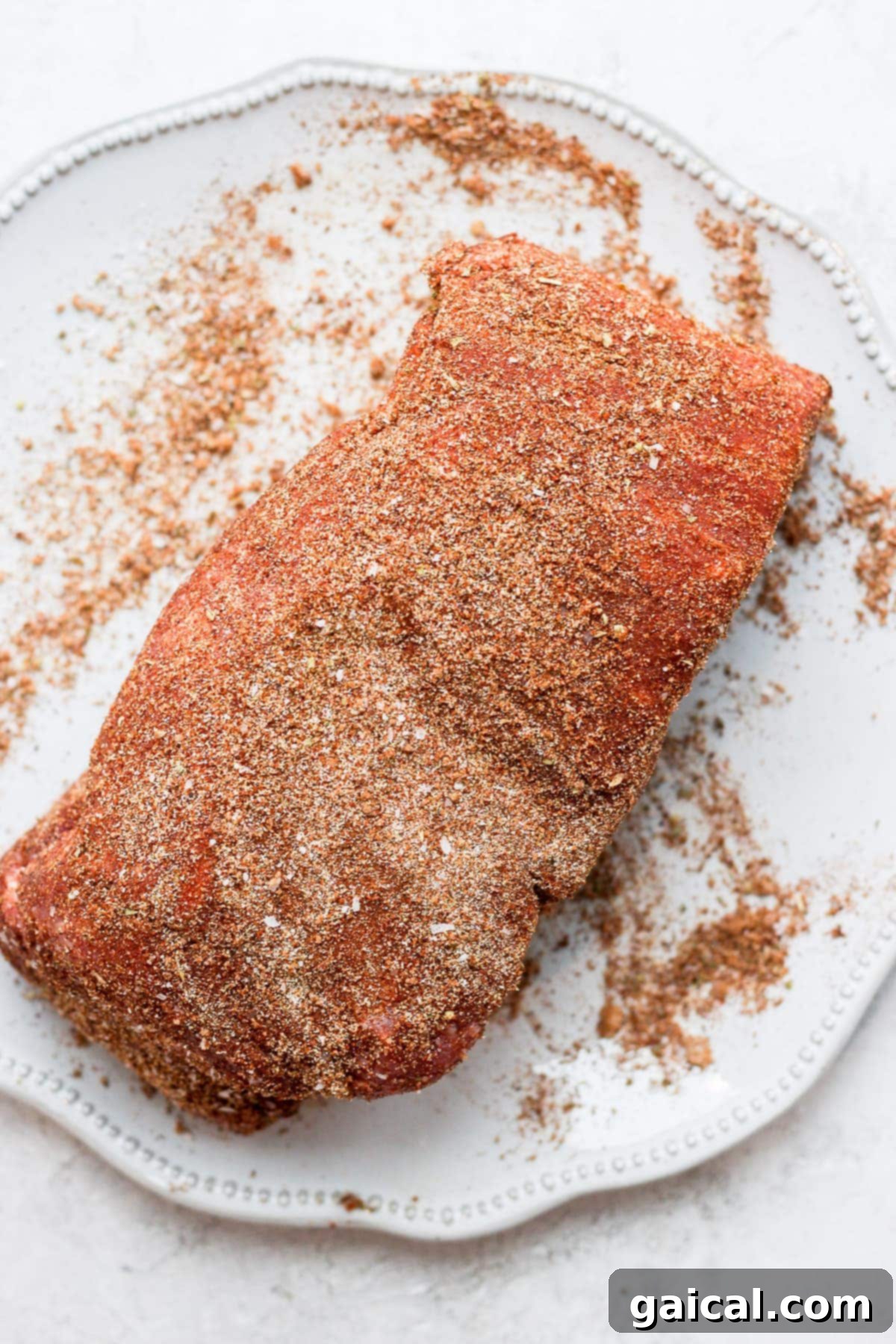 Perfect Homemade Carnitas 4 A pork roast generously covered in a savory dry rub of spices, ready for cooking.