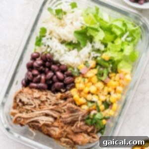 Perfect Homemade Carnitas 7 Carnitas burrito bowl in a meal prep container, featuring tender pork, street corn salad, and cilantro lime rice.