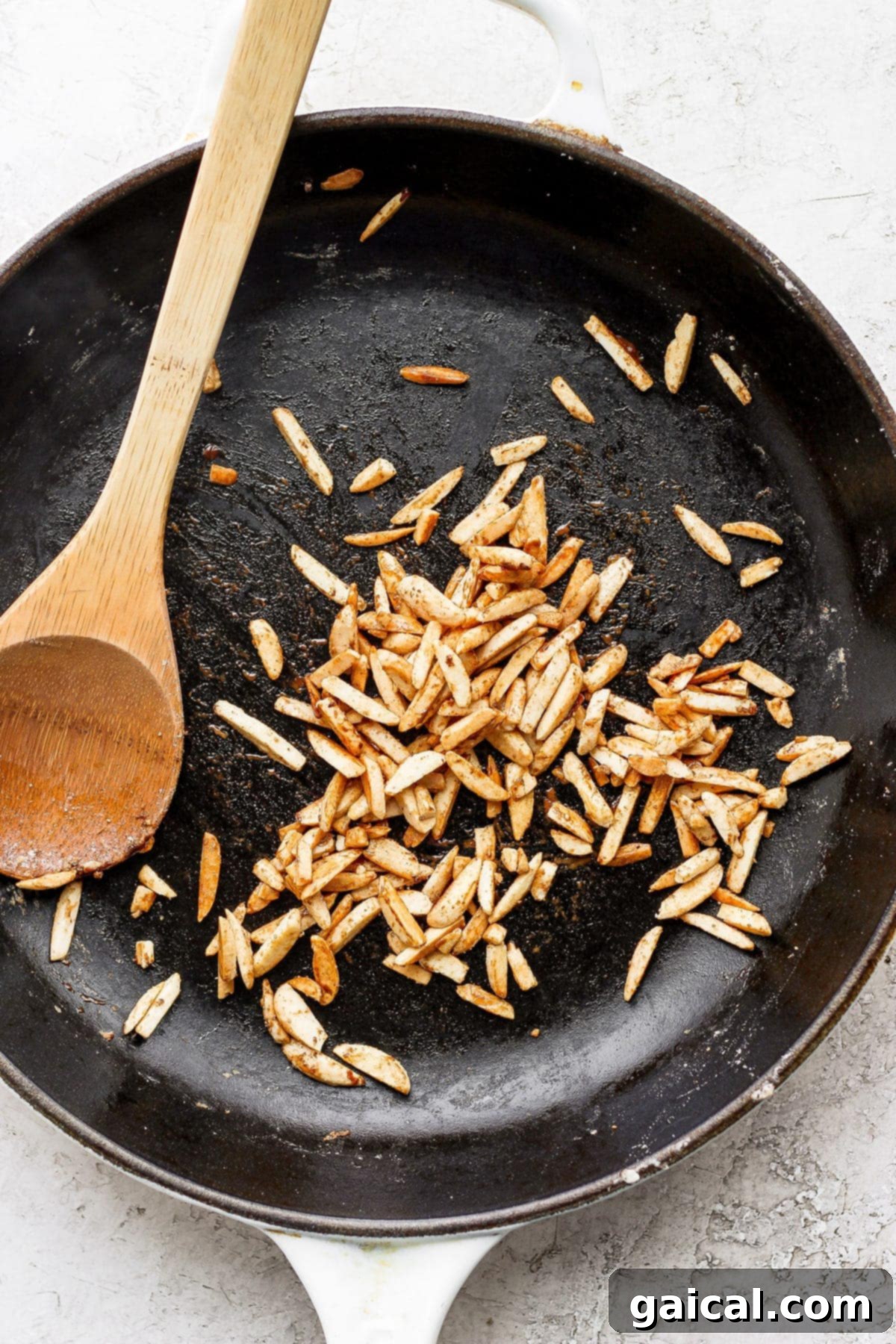 Slivered almonds toasting in a pan. 