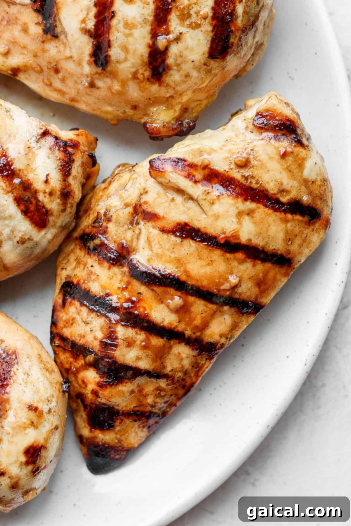 Succulent grilled chicken breast, sliced and ready to serve, showcasing perfect juiciness. A beautifully grilled chicken breast, perfectly sliced to reveal its juicy interior, presented elegantly on a white plate, ready for serving.