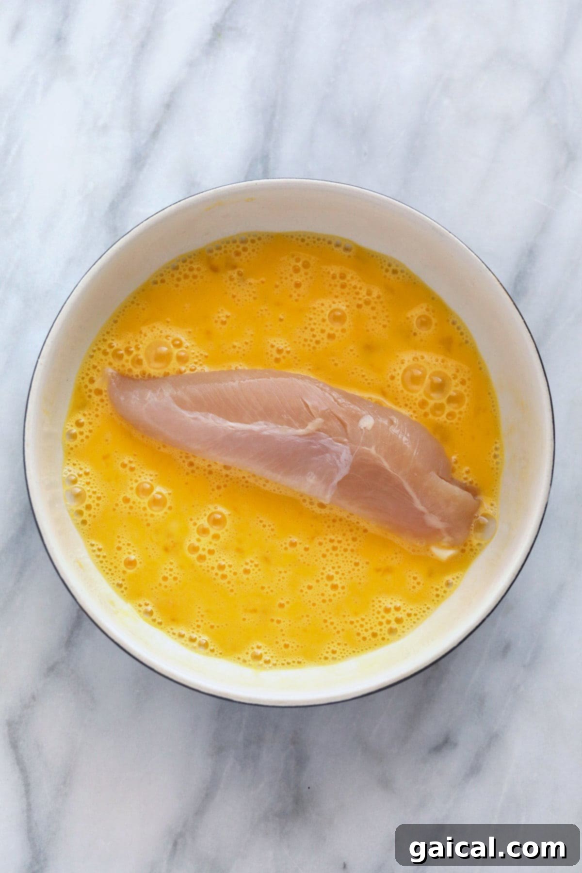 The most crispy on the outside and tender on the inside Air Fryer Chicken Tenders! These chicken tenders (air fryer style) are so easy to make, high protein, and kid-friendly. dipping chicken tenderloin in egg wash