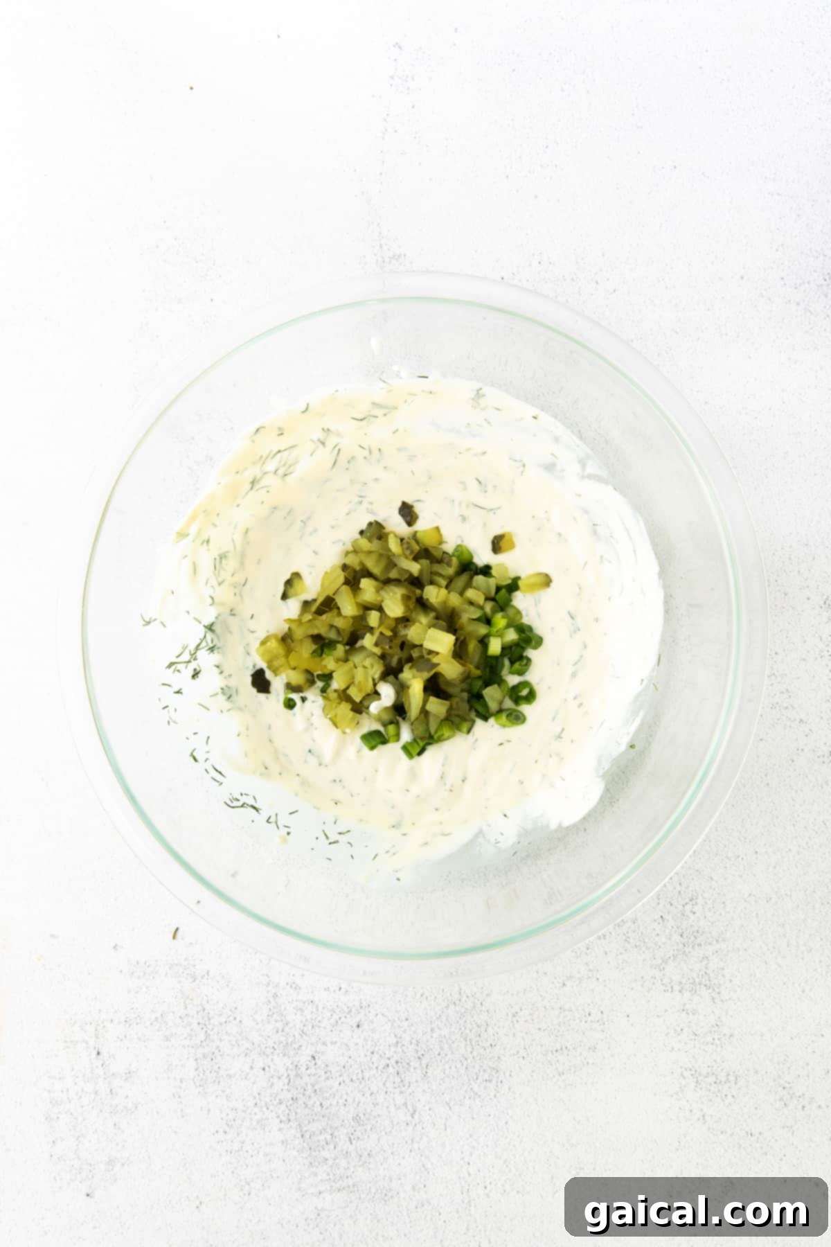 A bowl showcasing the creamy and zesty red potato salad sauce, ready to be mixed with potatoes.
