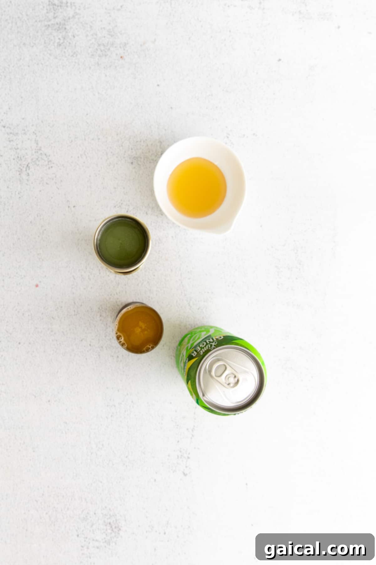 Key ingredients for a homemade virgin margarita: fresh lime juice, agave nectar, orange juice, and sparkling water. Fresh lime, orange, and agave nectar, ingredients for a virgin margarita, arranged on a kitchen countertop.