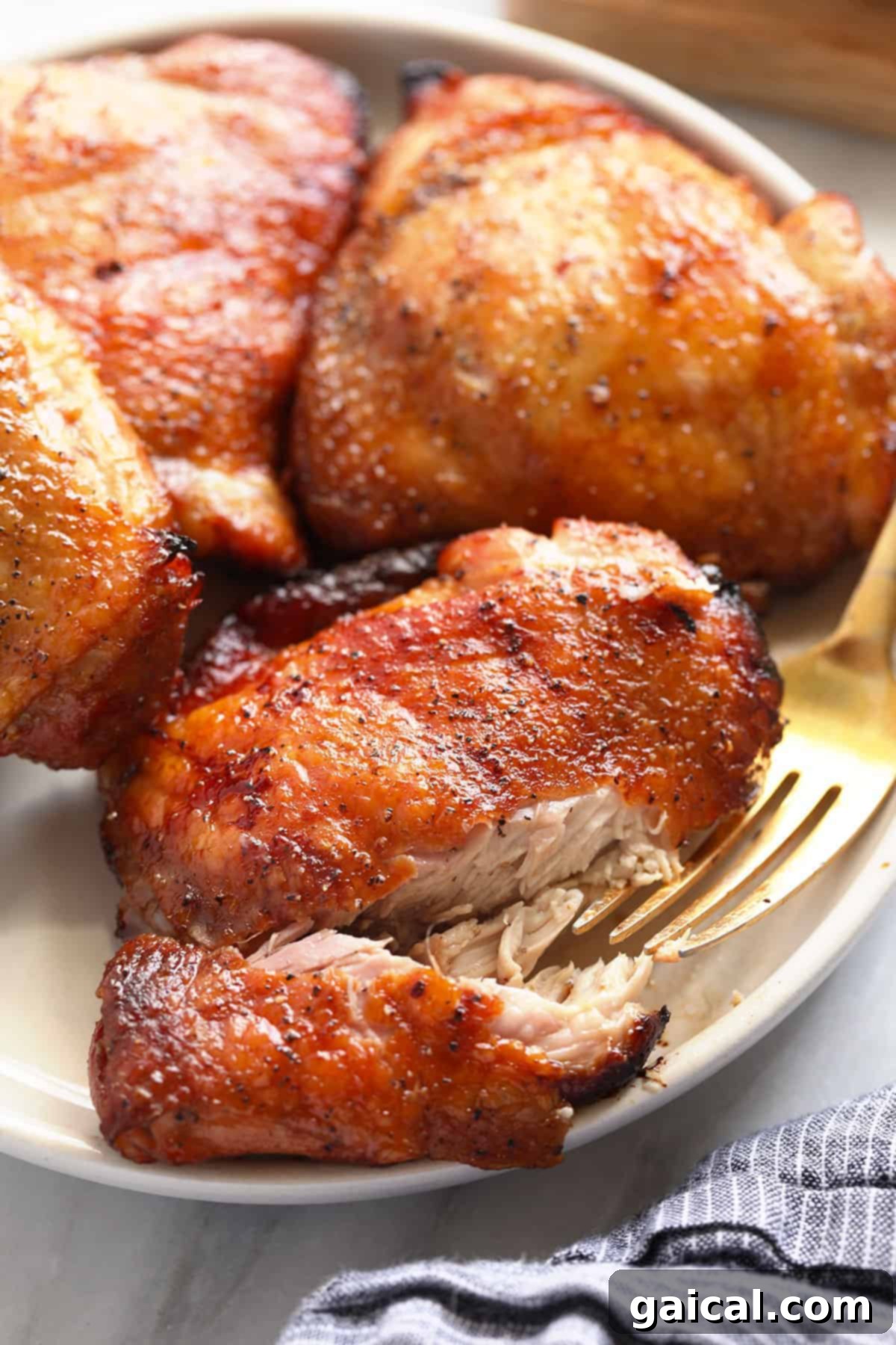 Perfectly Smoked Chicken Thighs 2 Smoked chicken thighs on a plate, perfectly cooked with crispy skin.