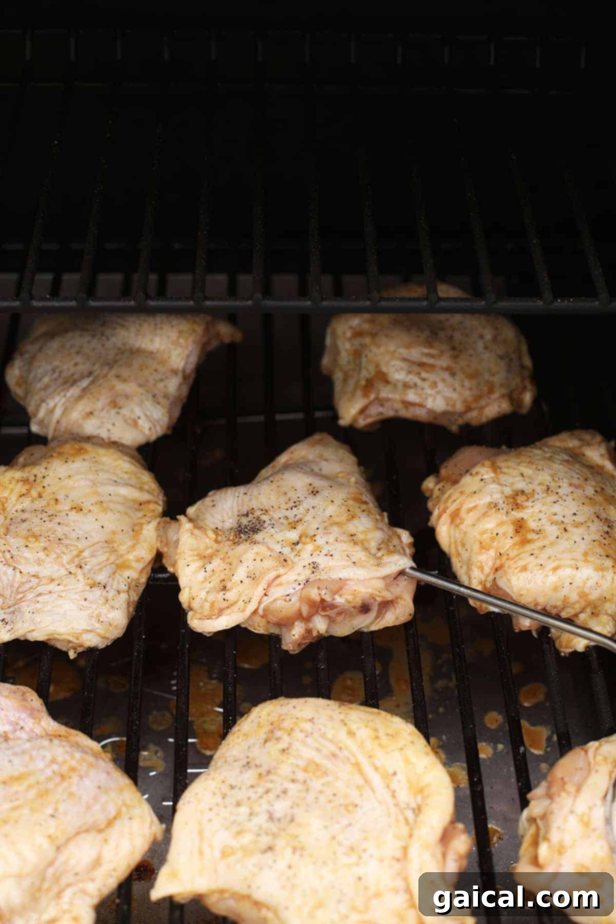 Perfectly Smoked Chicken Thighs 6 Chicken thighs smoking on a grill for perfect and flavorful results.