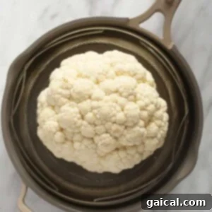 a head of cauliflower in a strainer.
