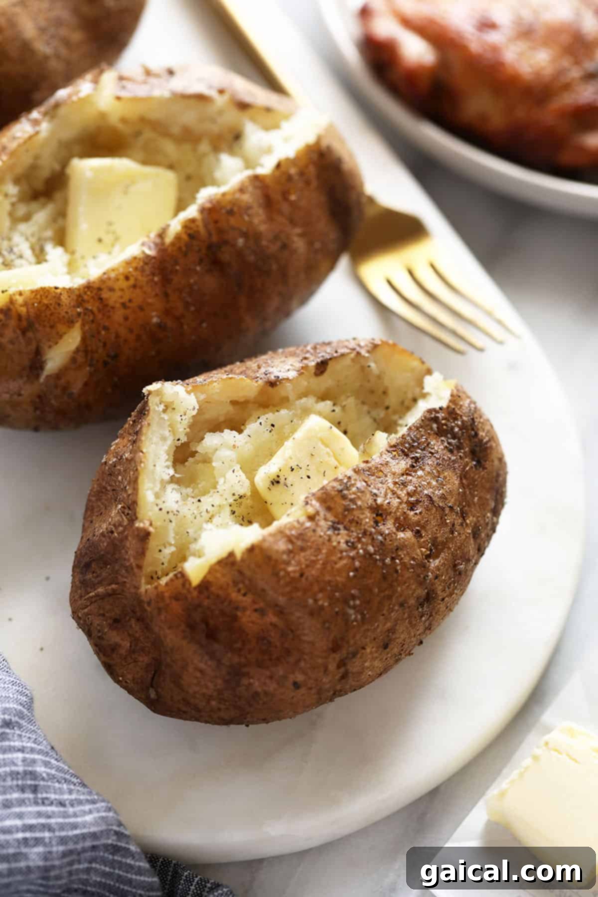 Super simple smoked baked potatoes that'll give you fork tender baked potatoes every time. butter, salt, and pepper in baked potato