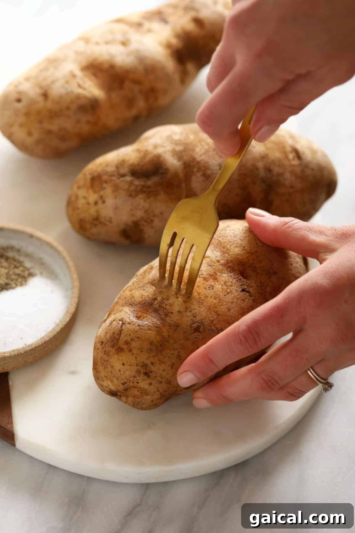 Super simple smoked baked potatoes that'll give you fork tender baked potatoes every time. poking hole in baked potato with fork