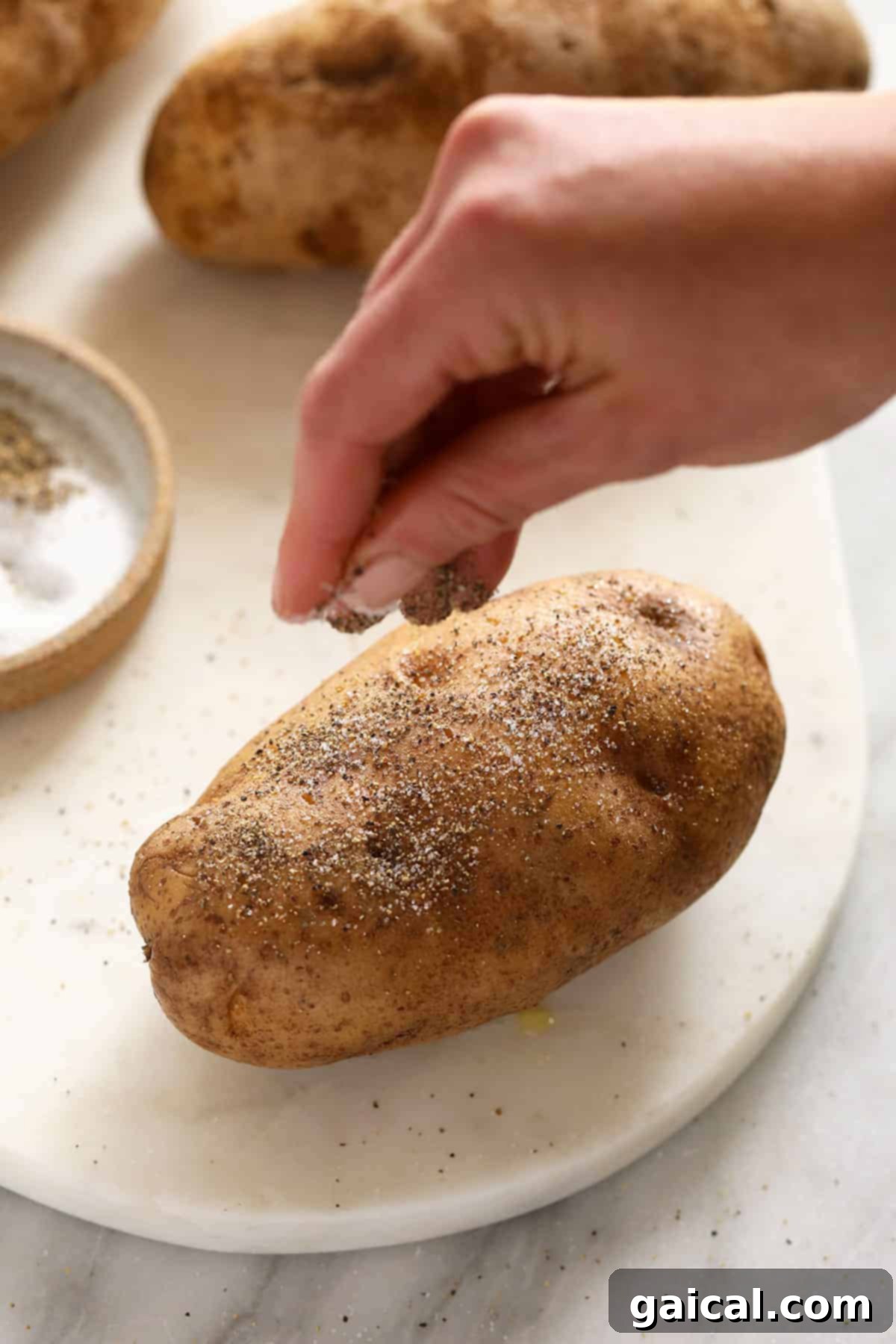 Super simple smoked baked potatoes that'll give you fork tender baked potatoes every time. salt and pepper on baked potato