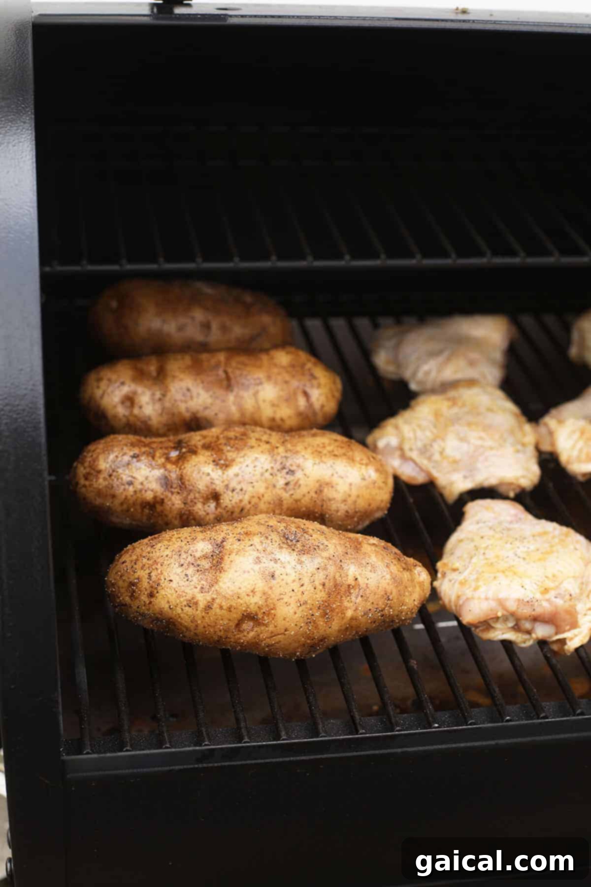 Super simple smoked baked potatoes that'll give you fork tender baked potatoes every time. baked potatoes on smoker with chicken thighs
