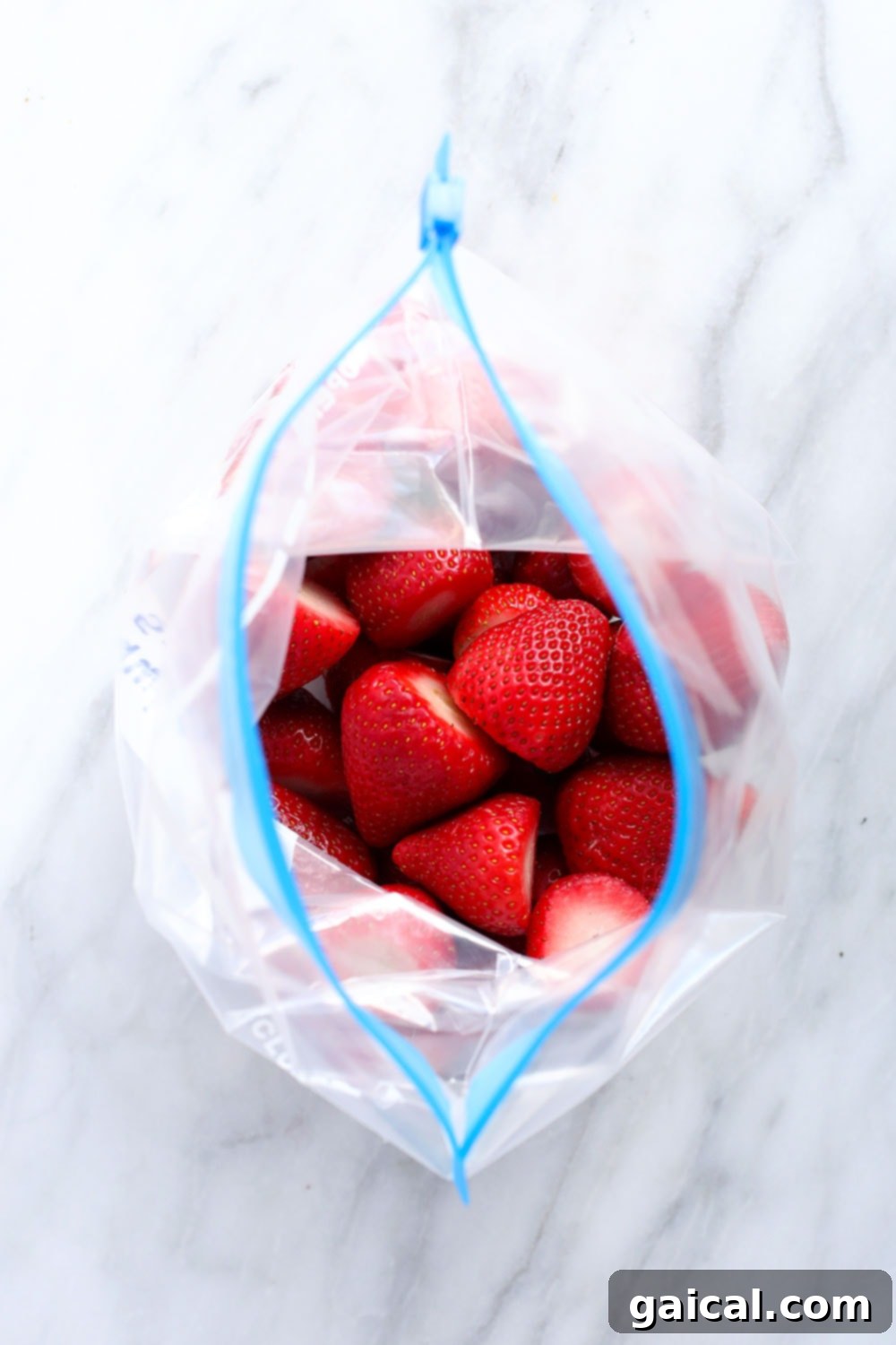 A transparent freezer bag filled with bright red frozen strawberries, showing how perfectly they can be preserved for long-term use.