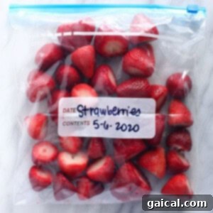 A transparent freezer bag of perfectly frozen strawberries, ready to be used in various recipes.