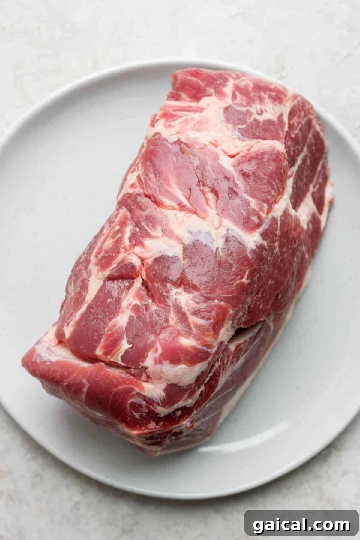 Close-up of perfectly slow roasted pork shoulder, glistening with juices and ready to be shredded for serving.