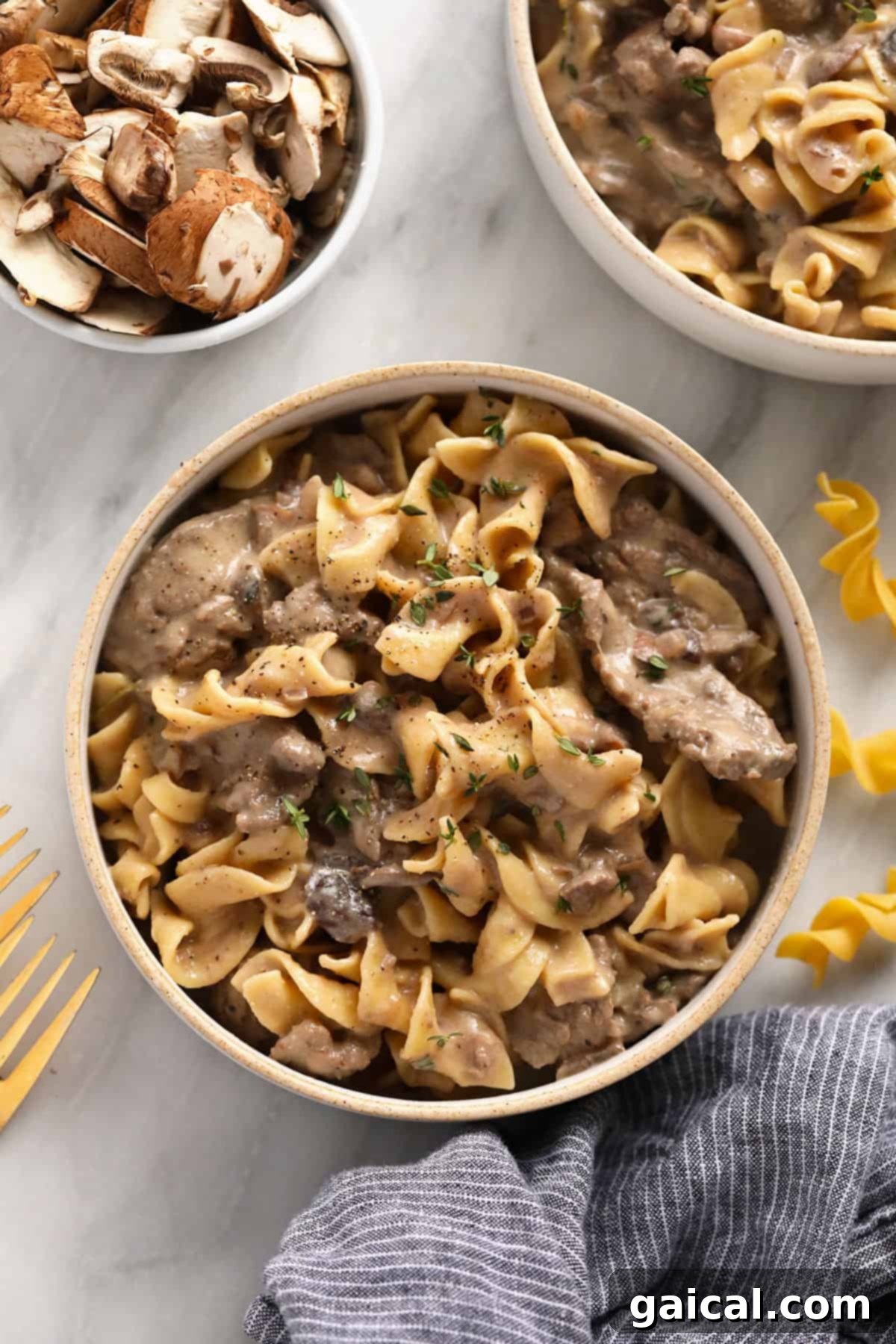 Simple Weeknight Beef Stroganoff 2 Beef stroganoff served over egg noodles in a bowl, garnished with fresh parsley.