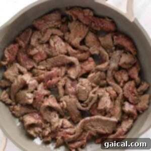 A skillet full of beef stroganoff on a marble countertop.