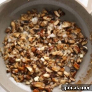 A skillet filled with mushrooms and onions, perfect for beef stroganoff.