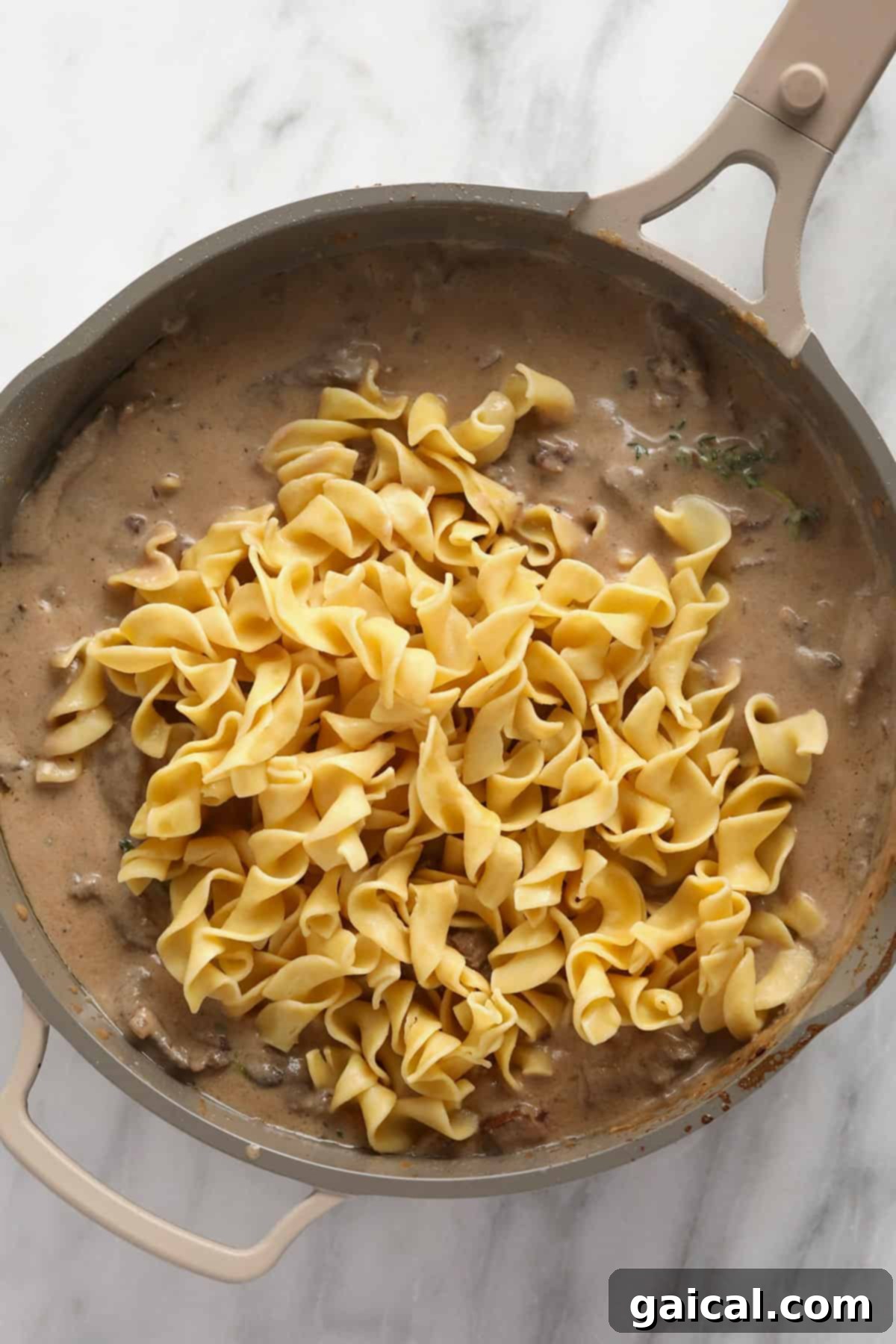 Simple Weeknight Beef Stroganoff 5 Classic beef stroganoff with egg noodles, served directly in the pan for a rustic presentation.