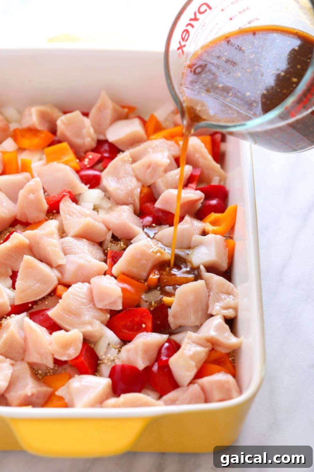 pouring sauce on chicken casserole