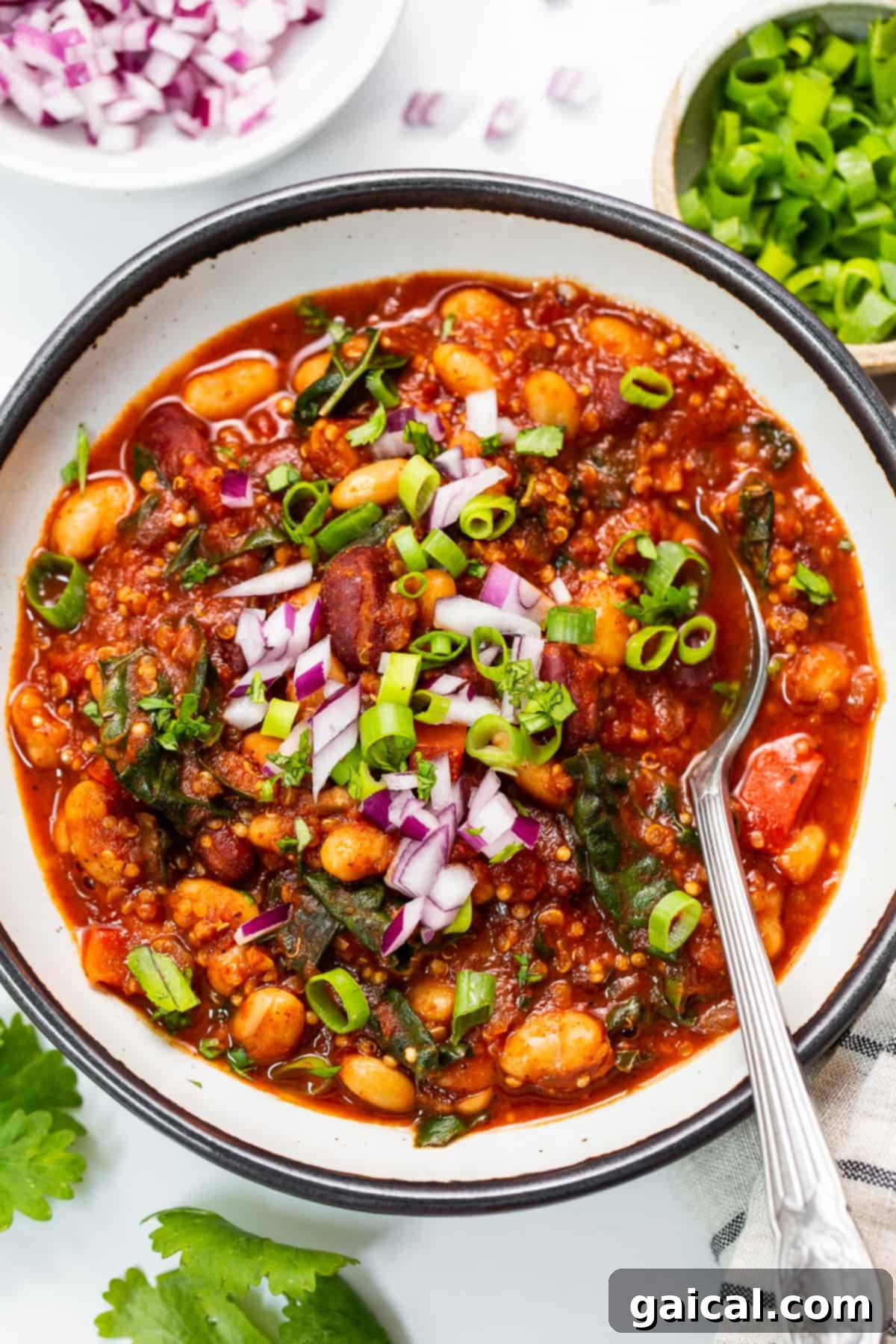 A nourishing and flavorful quinoa chili with roasted red peppers and jalapeños, rich in fiber and protein. A vibrant bowl of hearty quinoa chili, garnished with fresh herbs and a swirl of vegan cream, ready to be enjoyed.