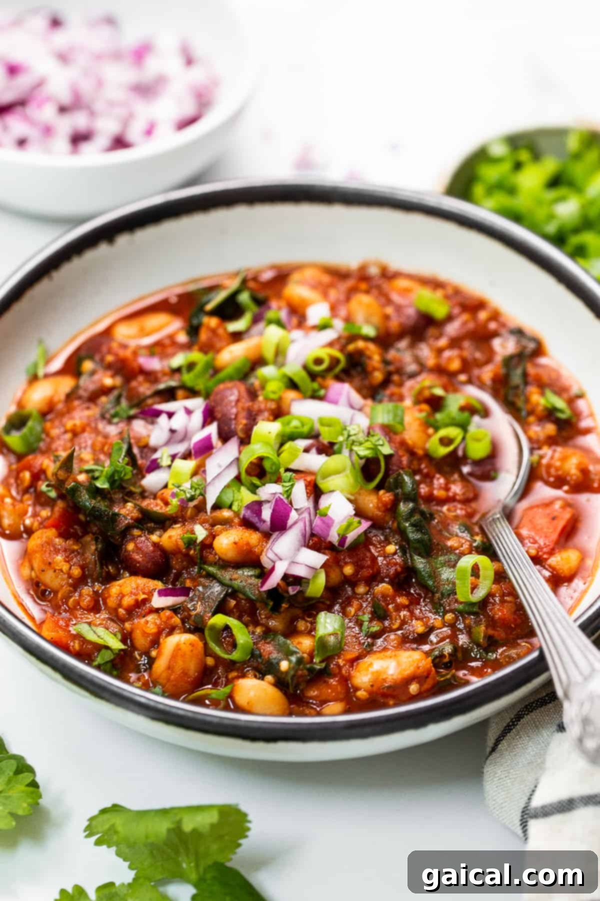 A comforting bowl of quinoa chili, perfect for a healthy and satisfying meal. A beautifully presented bowl of quinoa chili, adorned with fresh cilantro, a dollop of vegan sour cream, and a slice of lime.
