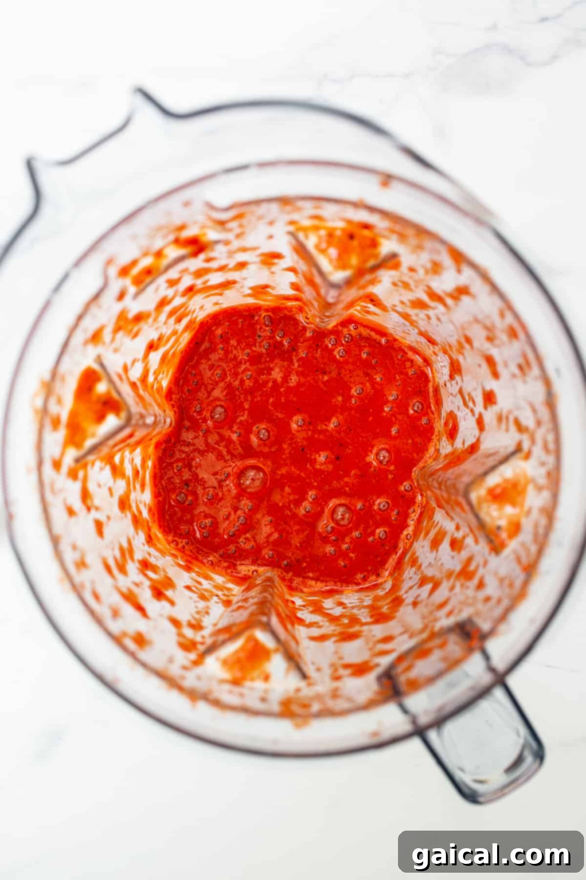 Smooth and flavorful blended roasted red peppers, a key ingredient for this nourishing quinoa chili. Roasted red peppers blended into a smooth, vibrant sauce in a mixer, ready to be added to the chili base.
