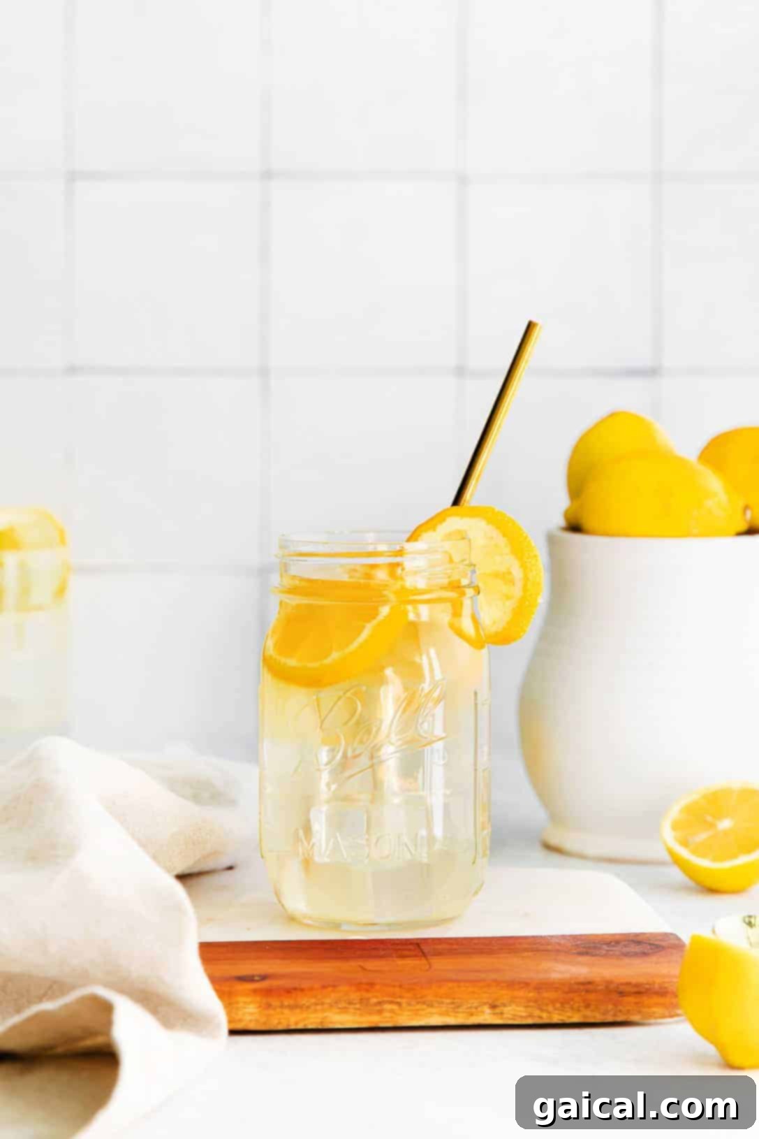 A refreshing glass of homemade lemonade with a straw and lemon slices, ready to be enjoyed.