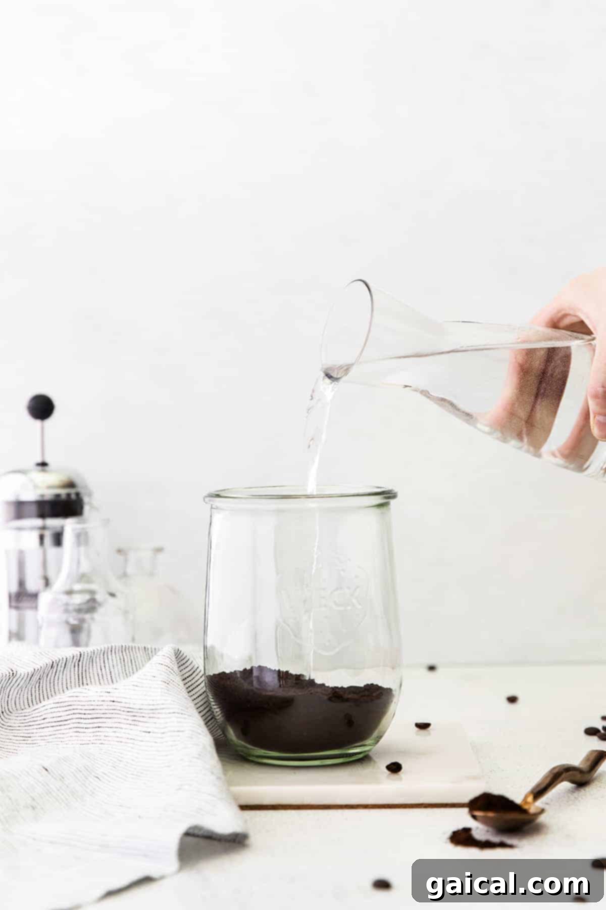 Crafting the Perfect Cold Brew 6 Pouring water over coffee grounds to make cold brew coffee.