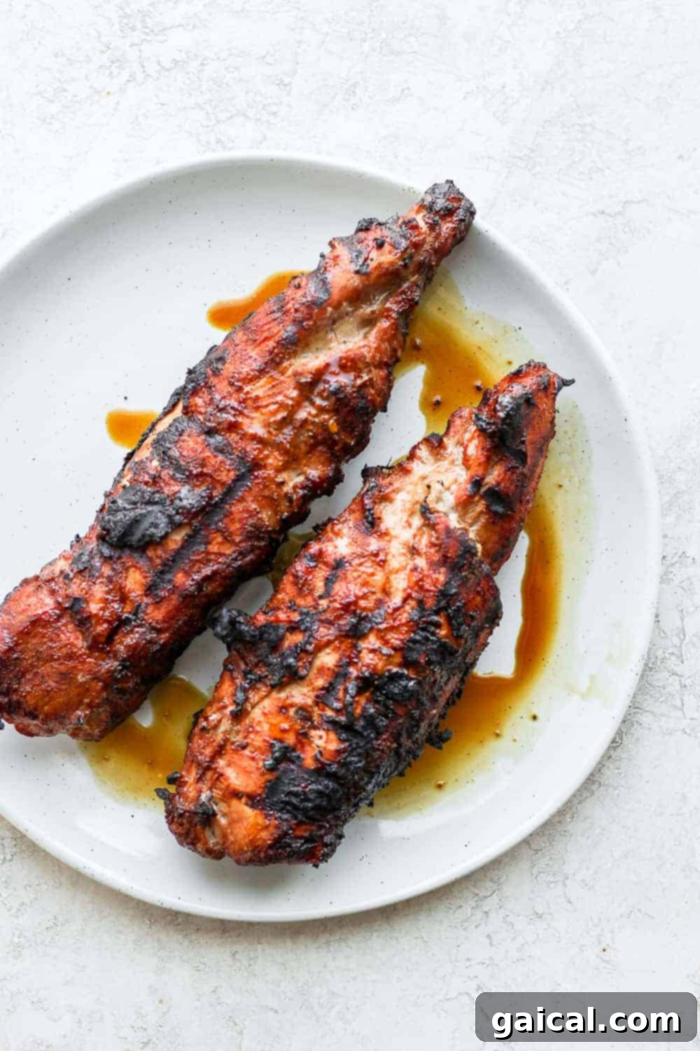 Two perfectly marinated pork tenderloins ready for cooking, showcasing their readiness for grilling or baking.