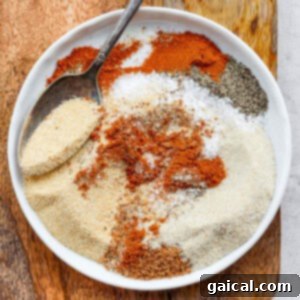 A top-down view of the smoked chicken dry rub, showcasing its fine texture and rich color, stored in a jar.